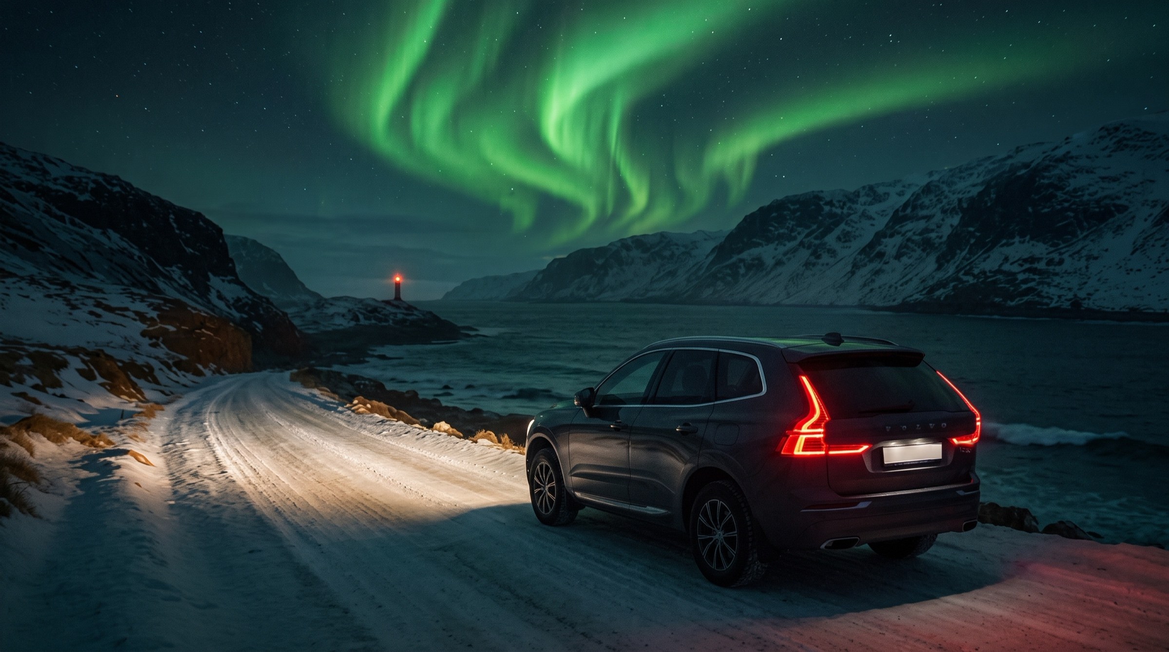 Volvo XC60 on a snowy coastal road under the northern lights
